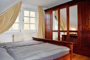 卑尔根Reetdachfachwerkvilla am Wiesengrund的一间卧室设有一张床和两个窗户。