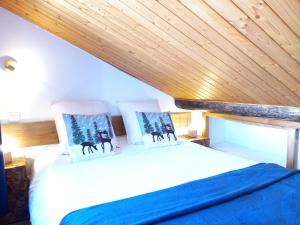 DoucyChalet de montagne au cœur de Doucy的木天花板的客房内的一张床位