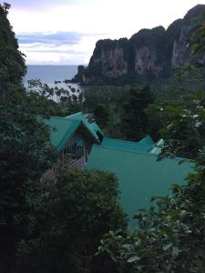 通塞海滩Garden View Resort Tonsai的一座带绿色屋顶的建筑,毗邻大海