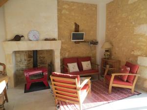 Lamonzie-MontastrucLes jardins de Peychenval的客厅配有红色椅子和壁炉