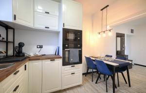 塔塔班亚Monos Apartman的厨房配有白色橱柜和一张带蓝色椅子的桌子。
