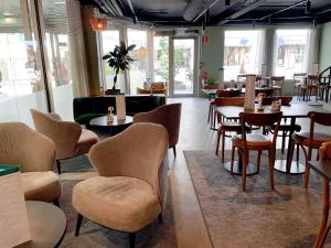 卡尔斯克鲁纳Best Western Plus JA Hotel Karlskrona的一间在房间内配有桌椅的餐厅