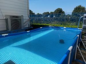 益城町Glamping Village LEAF的游泳池铺有蓝色瓷砖地板。