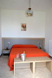 特龙扎诺拉戈马焦雷阿尔德格戴安娜酒店的一间卧室配有一张带红色毯子和桌子的床。