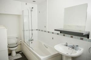 阿洛厄Tower Square House的白色的浴室设有水槽、浴缸和卫生间。
