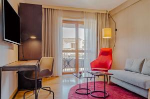 罗马罗马查士丁尼NH系列酒店的带沙发和红色椅子的客厅