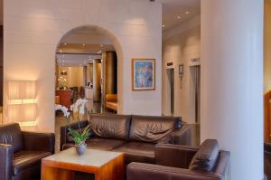 锡耶纳NH锡耶纳酒店的客厅配有真皮沙发和桌子