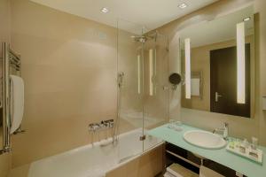 米兰米兰普雷西登特NH精选酒店的一间带两个水槽和玻璃淋浴间的浴室