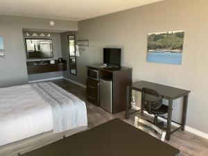 HendersonLake Norfork Resort的酒店客房配有一张床、一张书桌和一台电视。