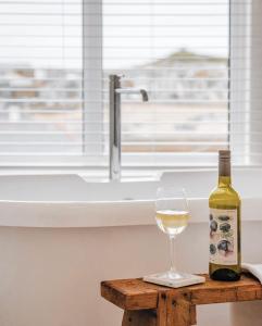 圣艾夫斯Harbour View House的一瓶葡萄酒和一张桌子上的一杯