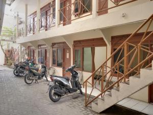 雅加达SUPER OYO 591 Mn Residence Syariah的停在大楼外的一组摩托车