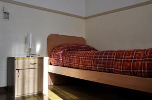 库尼奥Ostello Cuneo的一间卧室配有一张床,床上铺有铺着条纹毯子
