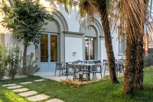 佛罗伦萨阿尔乐酒店的一个带桌椅的庭院和棕榈树