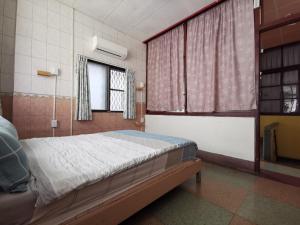 台南Goodyear 台南包棟民宿的一间卧室设有一张床和一个窗口