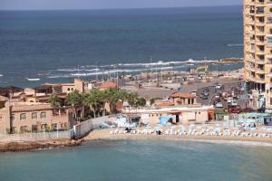 亚历山大Nour 1的海滩上,有椅子和建筑,还有大海