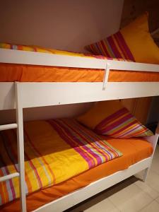 SimmelsdorfFerienhaus Baden的配有橙色毯子的客房内的两张双层床
