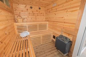 尚克林Pure relaxation at it's finest, offering moments of harmony and tranquillity - Sauna & Hot tub的木制桑拿房,设有长凳和垃圾桶