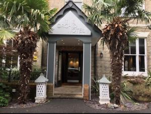 伯恩茅斯兰花酒店的前面有棕榈树的酒店入口
