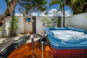 棕榈滩Boutique Hotel Swiss Paradise Aruba Villas and Suites的棕榈树后院的按摩浴缸