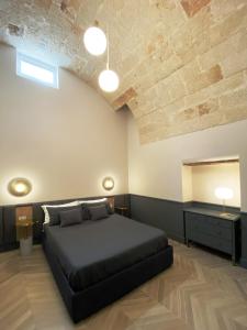 莫诺波利Dimore Garibaldi - Puglia Mia Apartments的一间卧室设有一张黑色的床和木制天花板。