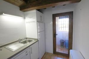 Valverde de la VeraApartamentos Rurales SPA Casa De Los Escudos的一个带水槽和窗户的小厨房
