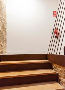 庞特维德拉Dúplex Camino de Santiago I, II y III, Rúa Real 26 y 28, Zona Monumental, Pontevedra的白色墙壁的房间的一套楼梯