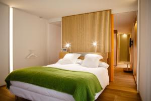 仕格莱伊卡伦美食酒店的一间卧室配有一张带绿毯的大床