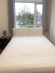 阿克斯桥利特尔顿旅馆的卧室配有白色的床和窗户