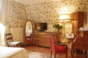 圣萨蒂南德玛内卡特纳酒店 - 勒芒的一间卧室配有一张床和一张书桌及电视