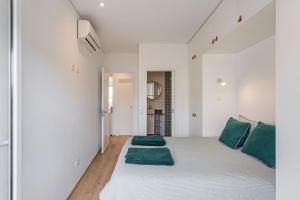 里斯本Tejo River View Apartment nearby Belém的卧室配有带绿色枕头的大型白色床