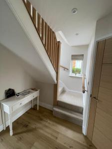 DunstallNewly renovated 3 Bed property - countryside views的客房设有带书桌和窗户的楼梯。