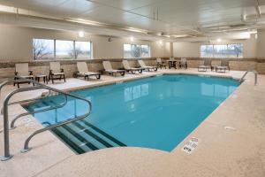 西塞尼卡Country Inn & Suites by Radisson, Buffalo South I-90, NY的一个带桌椅的大型游泳池