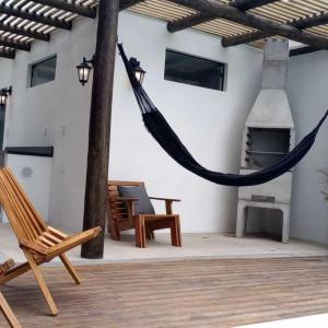Balneário GaivotasThe Guest House hostel的带壁炉的庭院内的吊床
