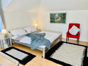 波普拉德Apartmán Residenz的一间卧室配有一张床和一张红色椅子