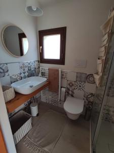 圣米歇尔迪甘泽Casa Vacanze La Cuntintizza的一间带水槽、卫生间和镜子的浴室