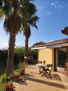 圣米歇尔迪甘泽Casa Vacanze La Cuntintizza的一个带桌子和两棵棕榈树的庭院