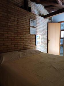 圣米歇尔迪甘泽Casa Vacanze La Cuntintizza的一间卧室设有砖墙和一张床