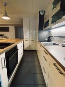 圣热尔韦莱班Bel appartement familial et cosy的厨房配有白色橱柜和黑烤箱。