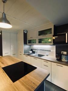 圣热尔韦莱班Bel appartement familial et cosy的厨房配有白色橱柜和木制台面