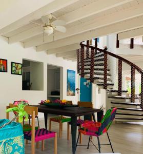 圣安德烈斯Casa de las Flores tropical的一间带桌椅和楼梯的用餐室