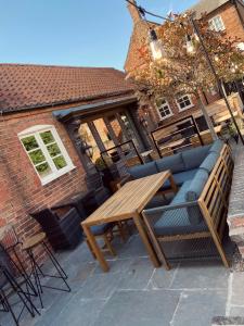 BinghamThe Wheatsheaf Pub, Kitchen & Rooms的庭院配有木桌和沙发。
