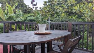 波尔兰特Malendure Bay Appartements的甲板上木桌,上面有盆栽植物