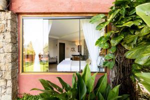 伊利亚贝拉Feiticeira Guesthouse的客房可通过窗户欣赏到一间卧室的景致。