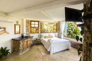伊利亚贝拉Feiticeira Guesthouse的一间卧室配有一张床、一个壁炉和一台电视。