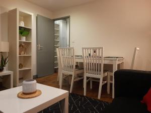 布尔日L'Orée du Marais - Paisible maison centre-ville的客厅设有餐桌和椅子