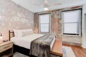 孟菲斯Historic Apartment in Prime Location的一间卧室设有一张床和两个窗户。