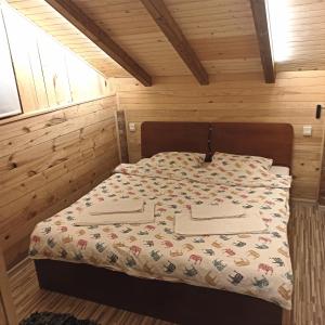 巴尼亚卢卡Villa FORESTA的木制客房内的一间卧室,配有一张床
