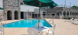 贝城Bay Valley Resort的游泳池旁带遮阳伞的桌子