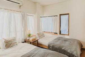挂川市White Space的一间卧室设有两张床和窗户。