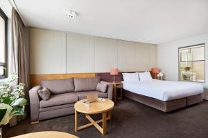 悉尼View Sydney的酒店客房,配有床和沙发